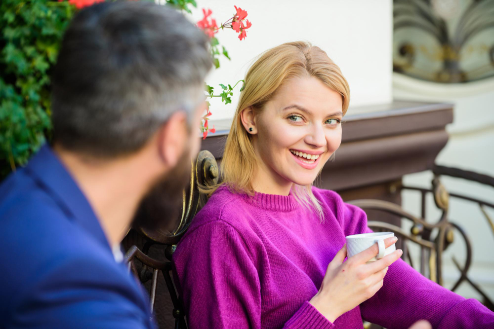 une femme avec un café sourit à un homme