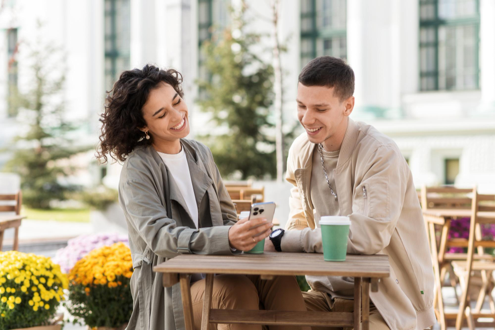 couple qui regarde un téléphone en terrasse