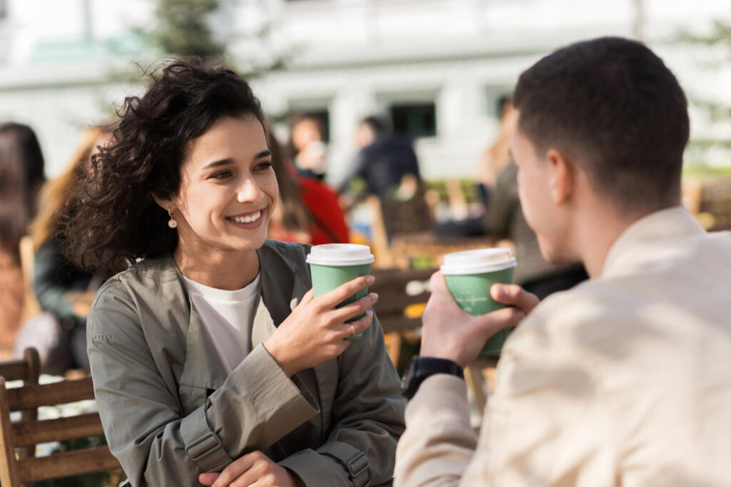 une femme et un homme qui boivent un café en terrasse