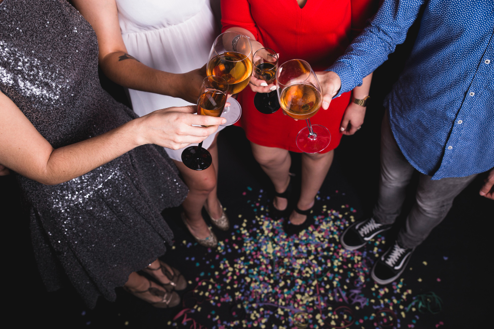 plusieurs personnes qui trinquent avec un verre de champagne à une soirée