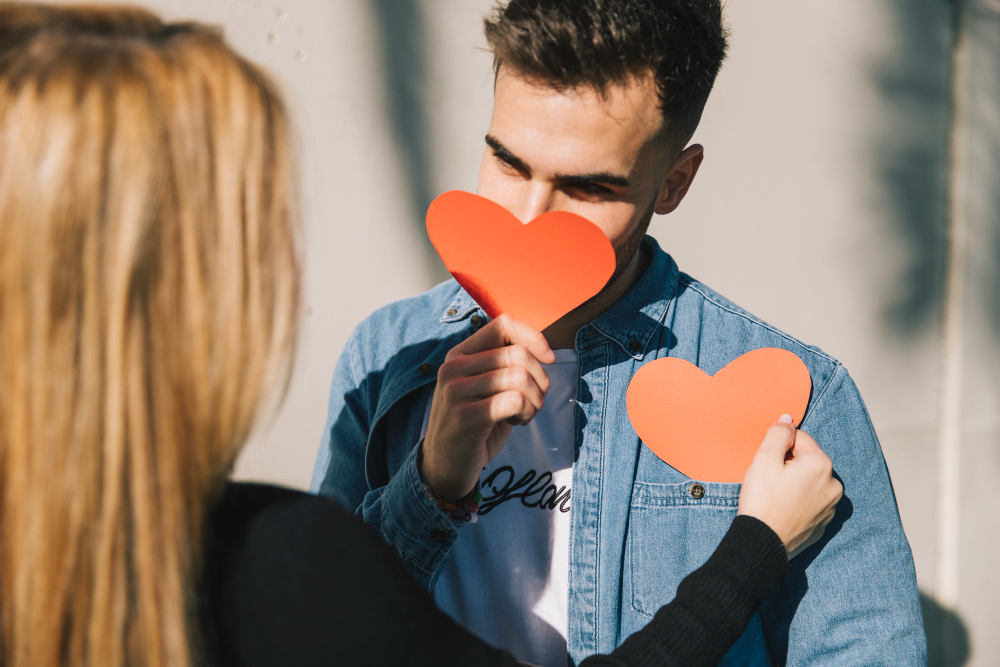 couple qui s'échange des cœurs en papier