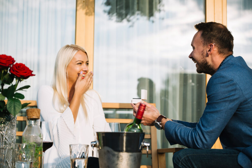 un couple avec une bouteille de vin en terrasse