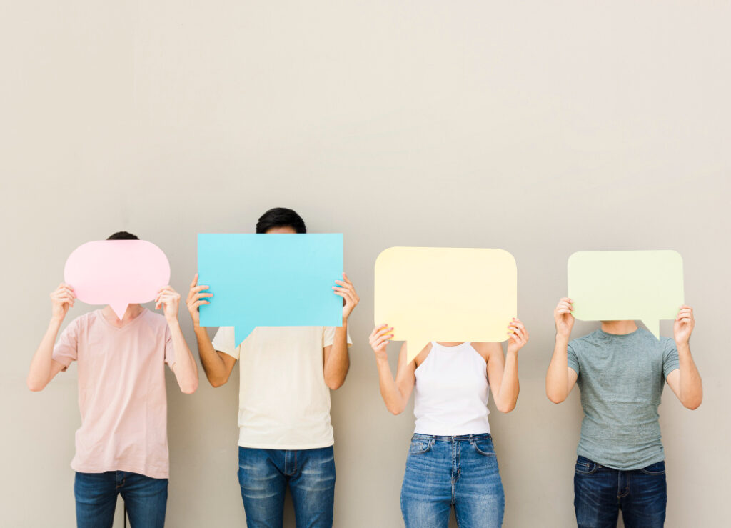 Plusieurs personnes se cachant le visage avec des feuilles représentant des bulles de discussion