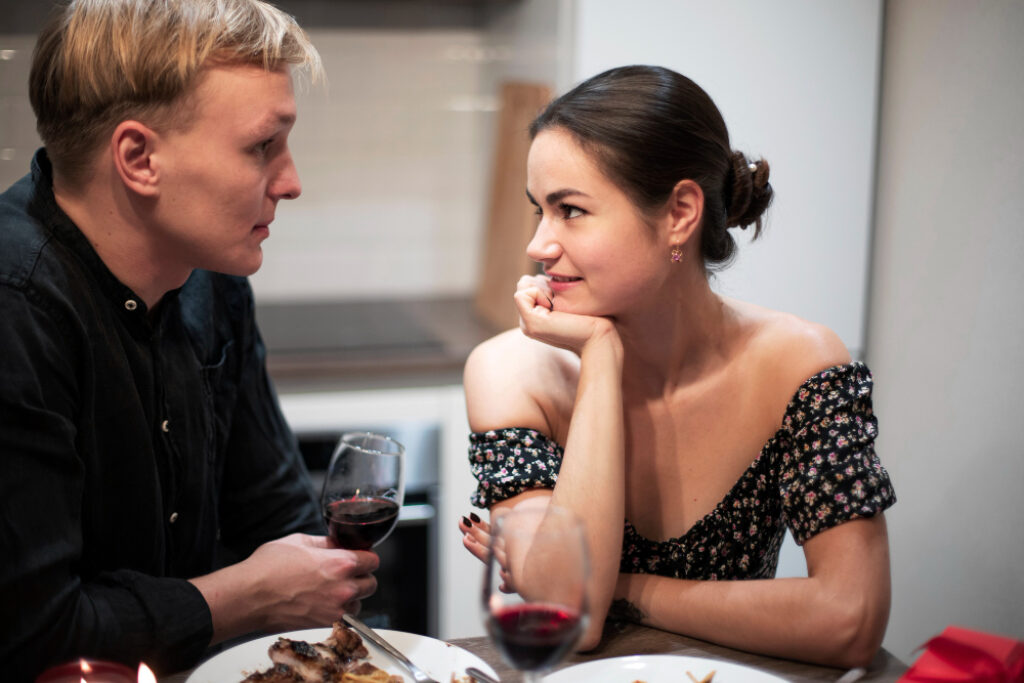 un homme et une femme buvant un verre de vin