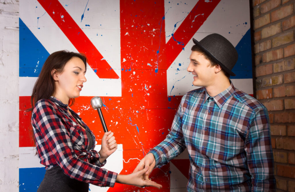 un homme et une femme devant le drapeau anglais sur le mur
