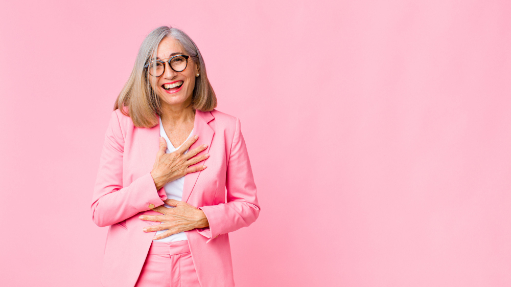 femme senior habillé en rose sur un fond rose