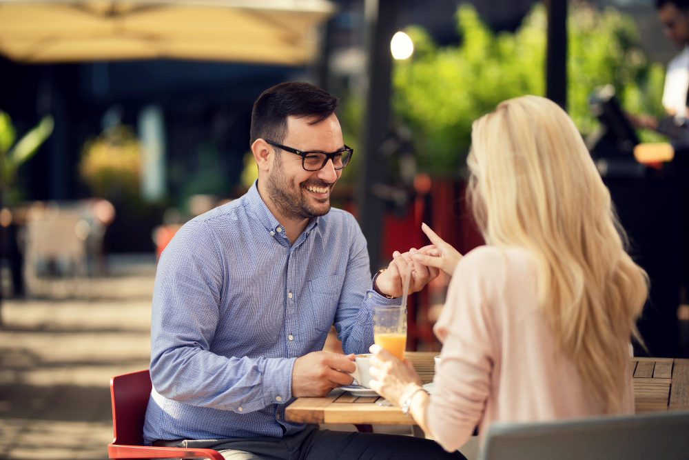 un homme et une femme se tenant la main à la table d'une terrasse