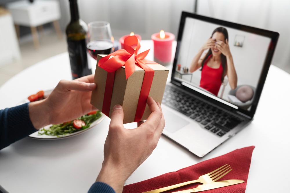 un homme en visio avec une femme et qui tend un cadeau face à l'ordinateur