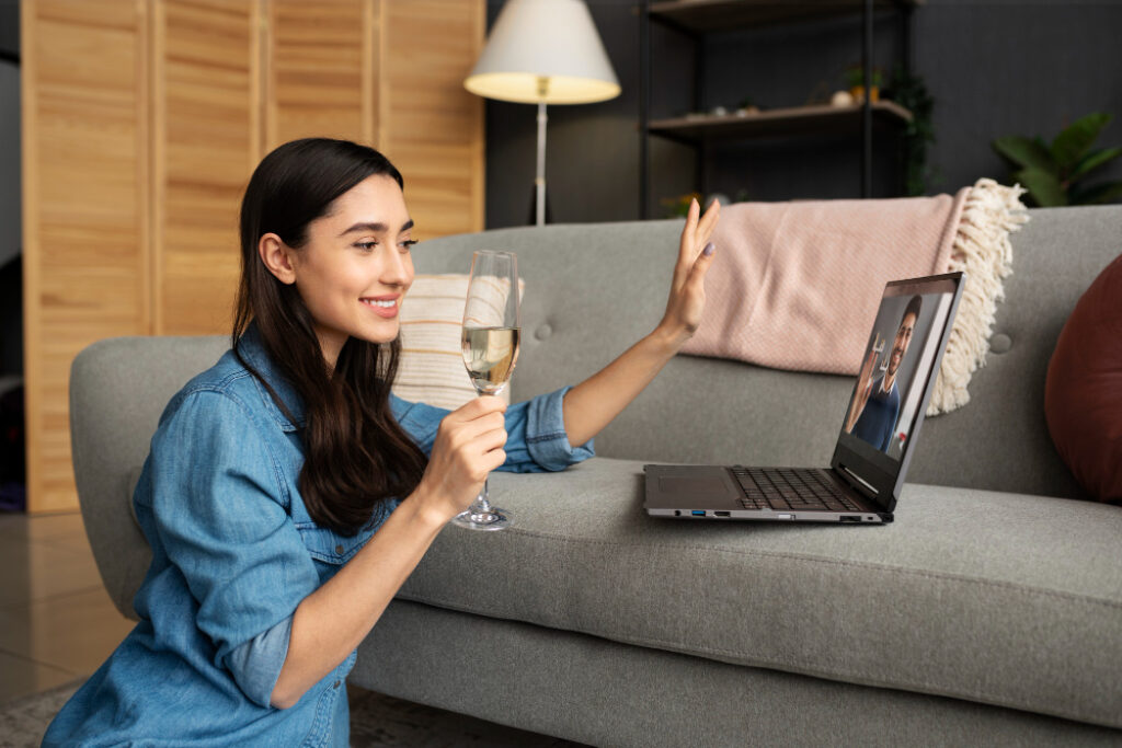 Femme avec un verre de vin face à son ordinateur