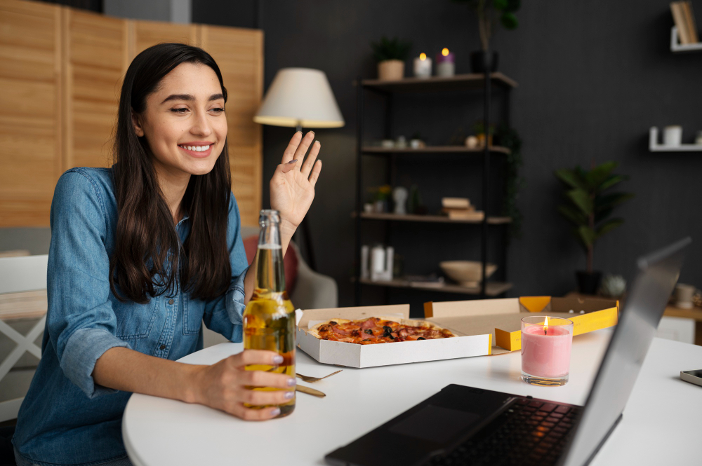 femme qui salue son ordinateur avec une bière dans la main